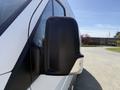Close-up of the side mirror of a 2016 Mercedes-Benz Sprinter van featuring a black casing and integrated turn signal light