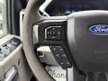 Close-up of the steering wheel in a 2020 Ford F-550 featuring buttons for controlling functions like cruise control and vehicle settings