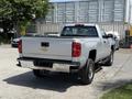 A silver 2016 Chevrolet Silverado 2500HD pickup truck viewed from the rear showing its cargo bed and tailgate