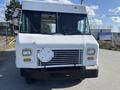 A white 2012 Ford Econoline with a flat front and large windshield features a metal grille and silver side mirrors