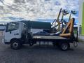 A 2019 Hino 195 truck with a flatbed and a mounted crane on the side