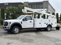 A white 2018 Ford F-550 with a bucket truck attachment and utility bed designed for service work