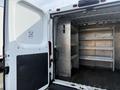 A 2017 RAM Promaster with the back doors open revealing a spacious, empty cargo area with metal shelving on one side