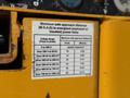A safety guideline sticker on a Haulotte Compact aerial lift detailing minimum safe approach distances to power lines at various voltage levels