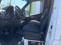 Interior of a 2022 Mercedes-Benz Sprinter showing the driver's seat and dashboard with controls and a dark fabric seat upholstery