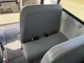 A gray bench seat from a 2011 Freightliner B2 with seatbelts attached