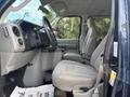Interior view of a 2013 Ford E-350 Super Duty showing the front seats and dashboard with gray upholstery and steering wheel