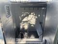 An open utility compartment of a 2008 International 4400 featuring hooks on the top and various tools and equipment holders along the bottom