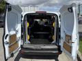 A 2021 Ford Transit Connect with its rear doors open exposing a spacious cargo area featuring a partition and a flat floor
