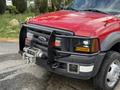 A red 2007 Ford F-550 truck with a front grille guard and a winch mounted on the front bumper