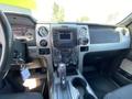 Interior of a 2014 Ford F-150 showing the dashboard gear shift and control panel with various buttons and display screens