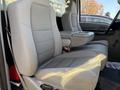 Interior view of a 2006 Ford F-550 showing two light gray fabric bucket seats with a center console between them