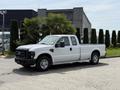 A white 2008 Ford F-250 SD with a standard cab and long bed parked, showcasing its front profile and side view