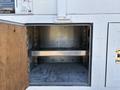 An open storage compartment on a 2006 Freightliner M2 106 with a metal interior and a single shelf visible inside