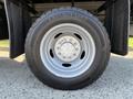 A close-up of a silver wheel and tire from a 2008 Ford F-450 SD featuring a black tire with visible tread and a bolt pattern on the rim
