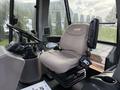 The interior of a 2005 Case 570 tractor featuring a plush driver seat with armrest and controls visible on the dashboard