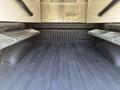 The interior of a 2019 Ford F-150 truck bed showing a smooth lined surface with metal cross rails on either side