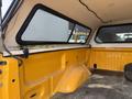 Interior view of a yellow 2014 Ford F-150 truck bed showing the walls and floor with a clear view of the rear cab area