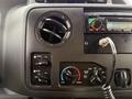Dashboard controls of a 2014 Ford Econoline featuring air conditioning vents a radio display and temperature adjustment knobs