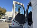 A 2005 Freightliner M2 106 truck with its driver's door open showcasing the interior and side mirror