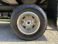 Close-up of a shiny wheel and tire from a 2021 Ford Econoline showcasing a silver rim and textured black rubber tire