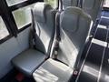 Two grey bus seats with seat belts inside a school bus