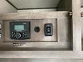 A control panel featuring a digital radio with buttons and a socket for electrical connections in a recreational vehicle