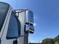 A close-up of a chrome side mirror on a 2020 Hino 338 truck reflecting the surroundings