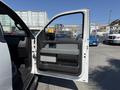A 2014 Ford F-150 with the driver's side door open showing the interior door panel and handle