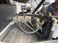 A close-up view of the hydraulic control system with multiple valves and hoses, featuring a pressure gauge on a 2012 Global M4 vehicle