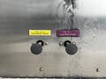 Two control knobs labeled "R.S. 4 in. DISCHARGE DRAIN" in yellow and "R.S. 4 in. SUCTION DRAIN" in purple located on a metallic surface