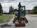 A 2017 John Deere 50G excavator with a large bucket attached positioned on a gravel surface facing forward