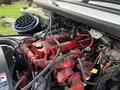 Detailed view of the engine compartment of a 2015 Freightliner M2 featuring red and black components along with various hoses and wires