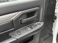 Close-up of the driver's door panel of a 2024 RAM 5500 featuring a handle and a control panel for windows and locks