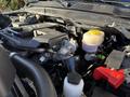 The engine compartment of a 2023 RAM 3500 showing the engine with various components including fluid reservoirs and tubing