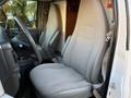 Interior view of a 2015 GMC Savana showing the driver's seat with gray upholstery and a steering wheel