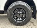 A close-up of a black wheel and tire from a 2013 Ford F-250 SD with an aggressive tread pattern and a shiny rim