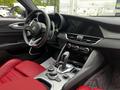 2023 Alfa Romeo Giulia interior featuring a sleek dashboard with a digital display red leather seats and a central console with controls and gear shift