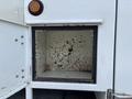 Open compartment of a 2006 International 4300 truck showing rust stains and dirt on the interior walls