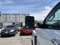 A 2020 Chevrolet Silverado with a side mirror visible in the foreground positioned next to other vehicles