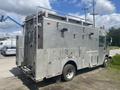 A silver 2007 Morgan Olson Workhorse W42 vehicle with side compartments and equipment on top, designed for utility work and maintenance
