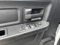 Close-up of the door panel of a 2013 RAM 1500 showing the door handle and power window controls with multiple buttons