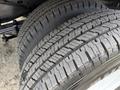 Close-up of the tread patterns on two tires of a 2022 Ford E-450 showcasing deep grooves and well-defined rubber for traction and stability