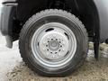 Close-up of a 2015 Ford F-450 wheel showing a silver alloy rim with multiple bolt holes and a textured tire tread