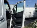 A 2019 Mercedes-Benz Sprinter van with the side door open, revealing the interior featuring a dashboard and seating area
