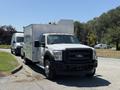 2013 Ford F-550 truck with a white body and a silver metallic service box mounted on the back