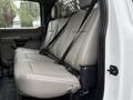 A 2022 Ford F-550 truck interior featuring a spacious rear bench seat with gray leather upholstery and seat belts