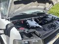 A 2020 Chevrolet Express with the hood raised exposing the engine compartment featuring various components such as the battery coolant reservoir and wiring