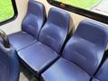 Three blue upholstered seats arranged in a row with a textured surface in a vehicle interior