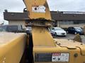 A 2015 Vermeer Corporation BC1200XL wood chipper with warning and safety labels visible on its chute and body